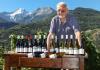 Il proprietario di Maison Anselmet con i suoi vini e, sullo sfondo, la Grivola