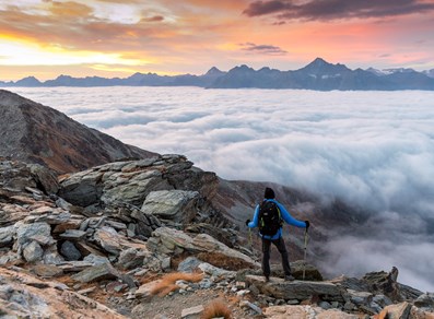 Wanderer bewundert das Wolkenmeer von der Becca di Viou
