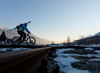 By bike, carrying skis towards the start of the Aosta-Pila gondola