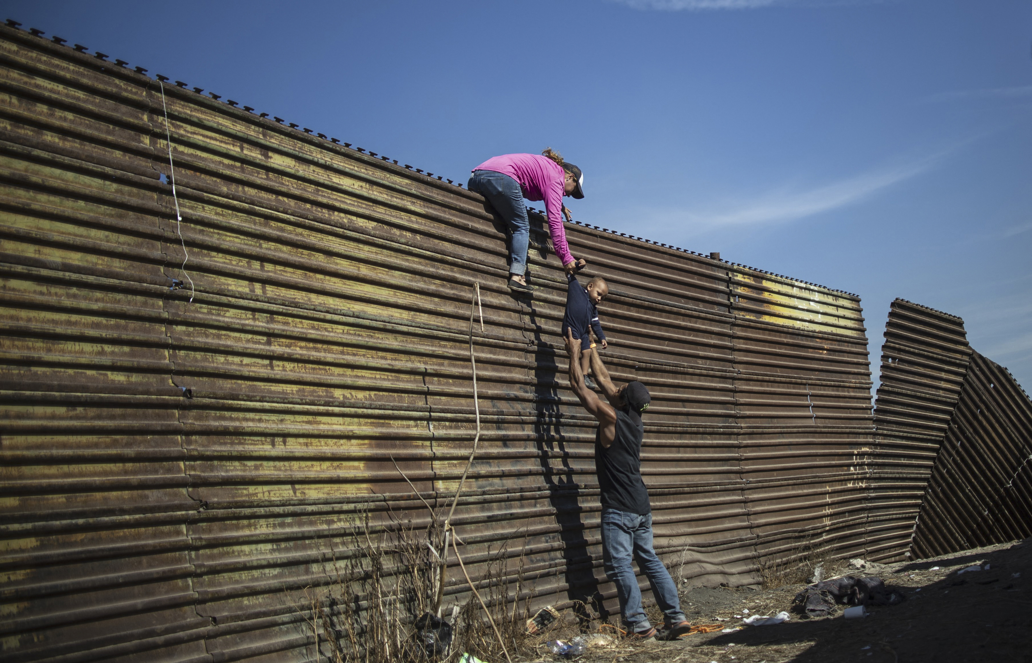 Photo credit: Pedro Pardo - AFP PHOTO
Una famiglia di migranti che attraversa il muro tra Messico e Stati Uniti