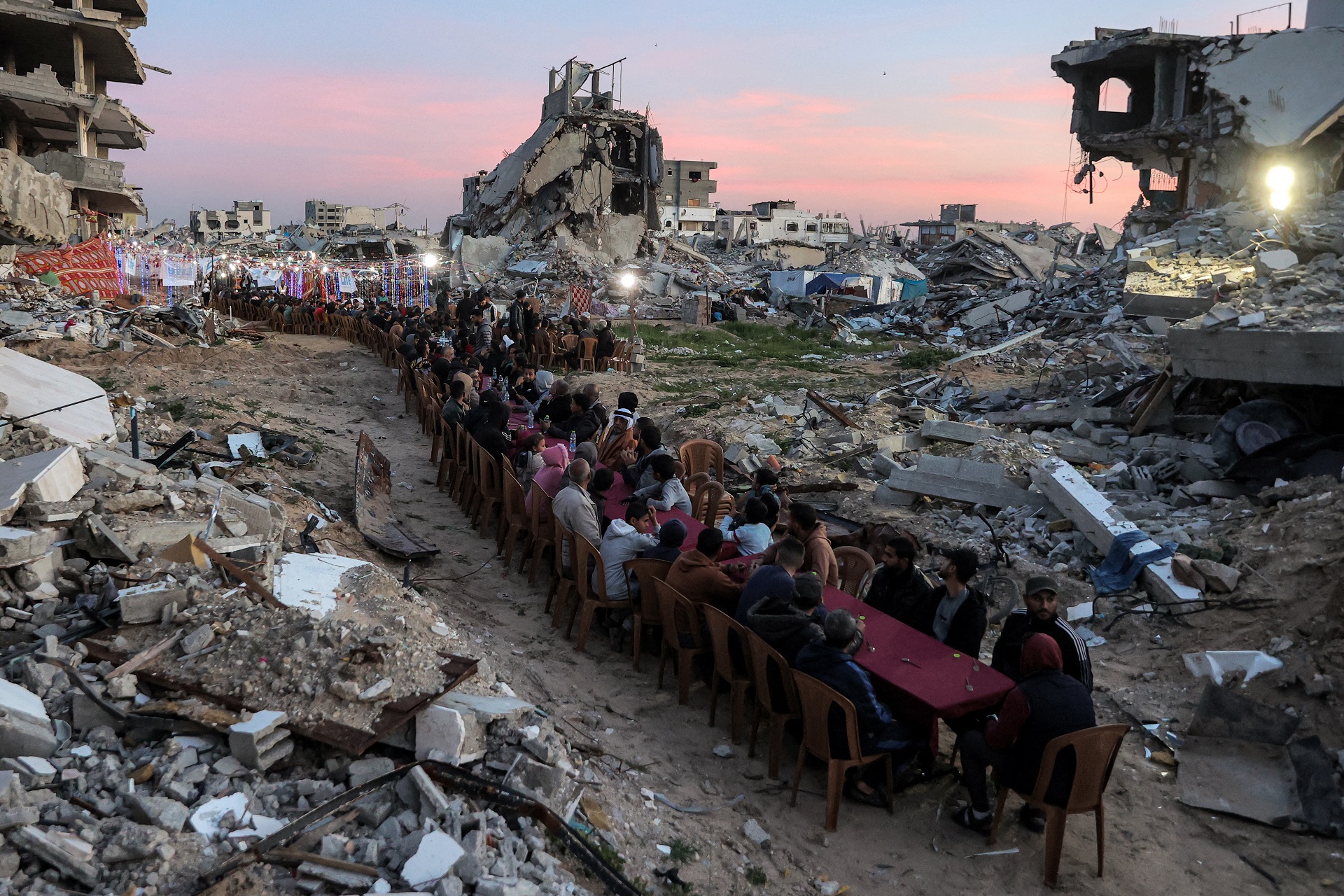 Omar Al-Qattaa / AFP 2/3/2025
Una lunga tavolata tra le case distrutte di Gaza per la cena dell’ifṭār durante il Ramadan.